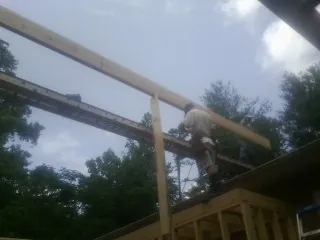 Carpenter setting a ridge beam over a new addition frame — Ice Dam Removal by Roofing Brothers in Lackawaxen
