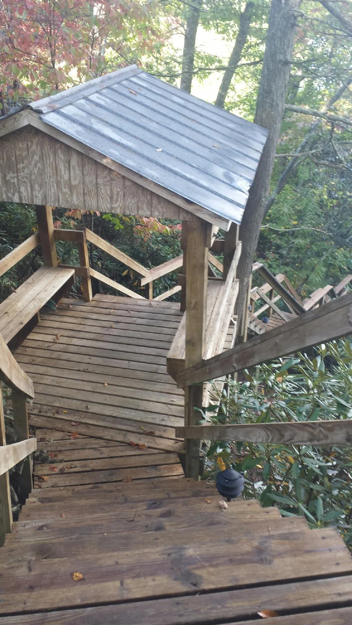 Metal roofed shelter over wooden steps on a wooded walkway — Skylight Repair & Installation work by our crew in Lackawaxen