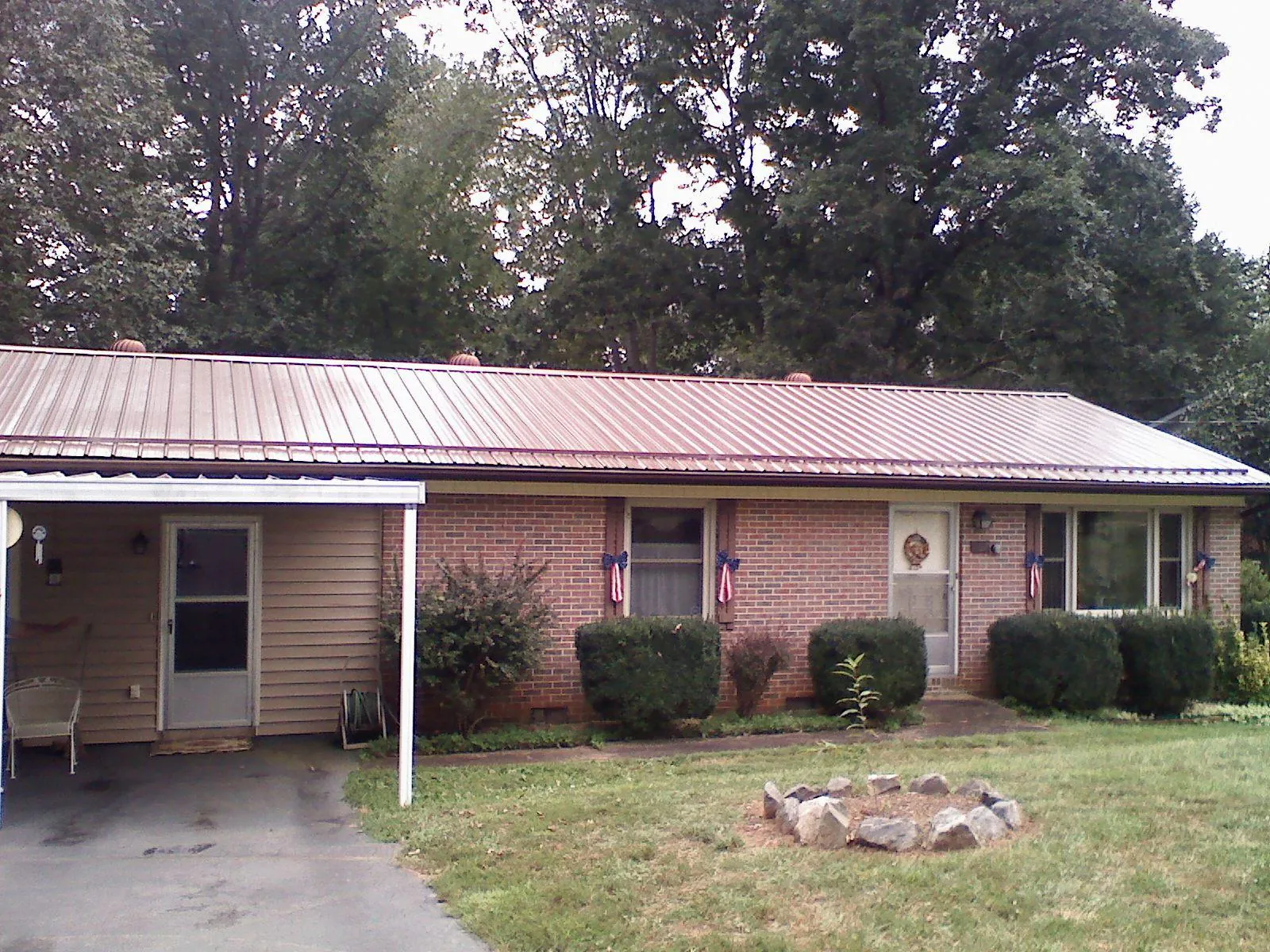 Bronze metal roof and carport on a brick ranch home — Roof Repair work by our crew in Lackawaxen